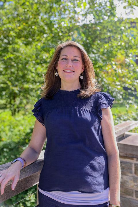 woman standing on bridge with trees in background